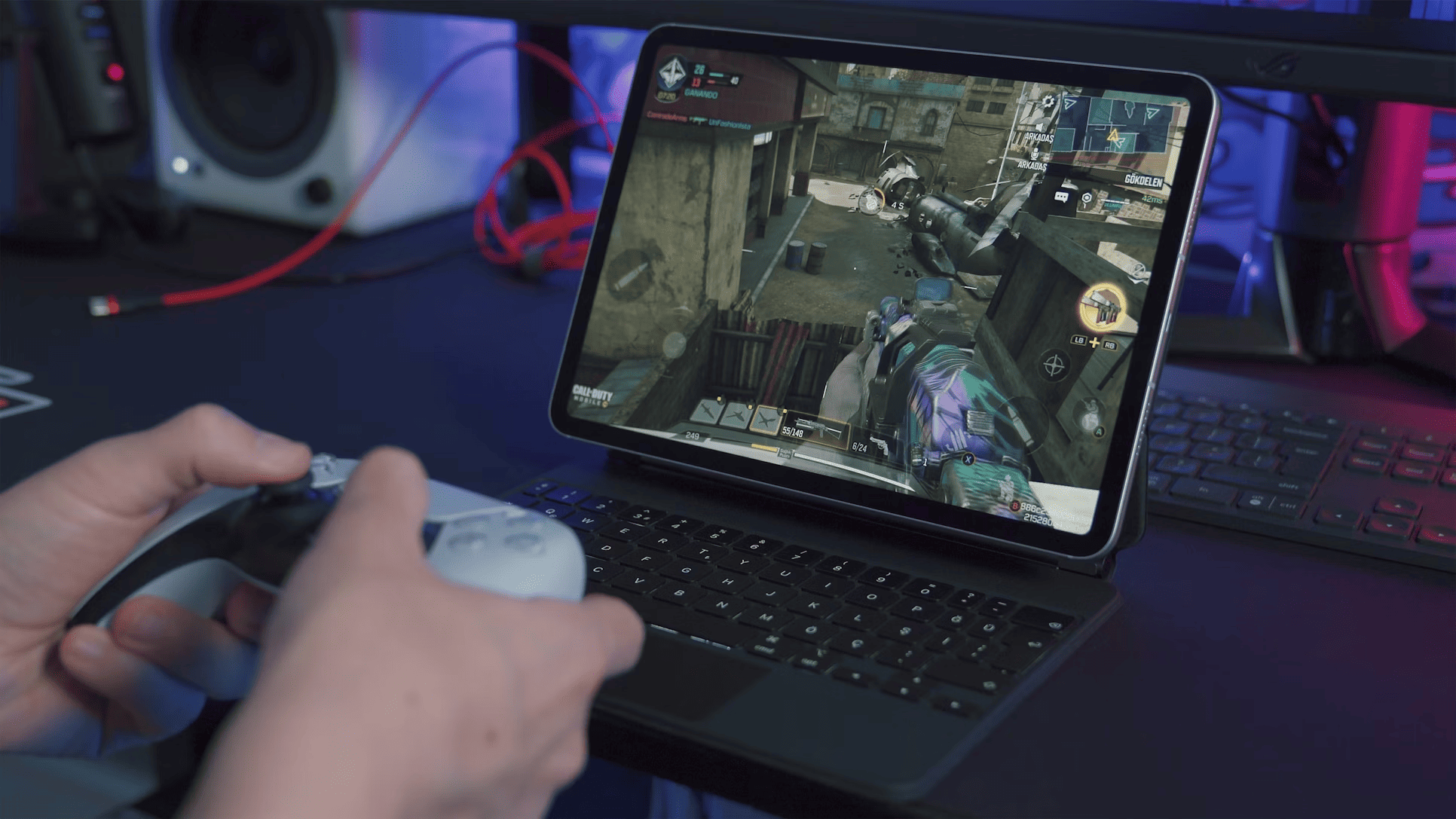 Person holding game controller in front of laptop