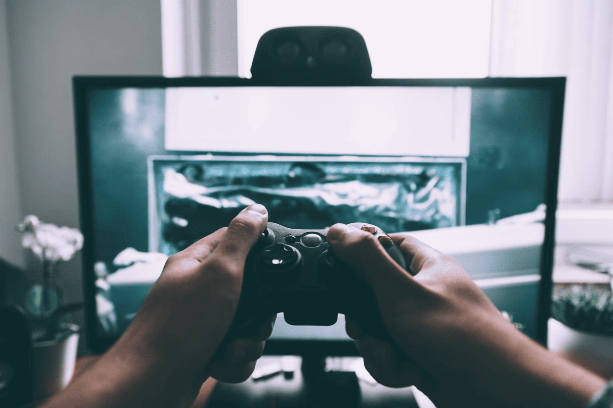 Person holding game controller in front of television